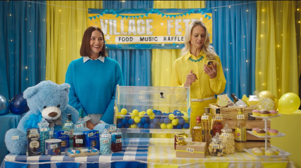 Two women at a village-hall raffle in Lebara's Smarter Mobile Network campaign.