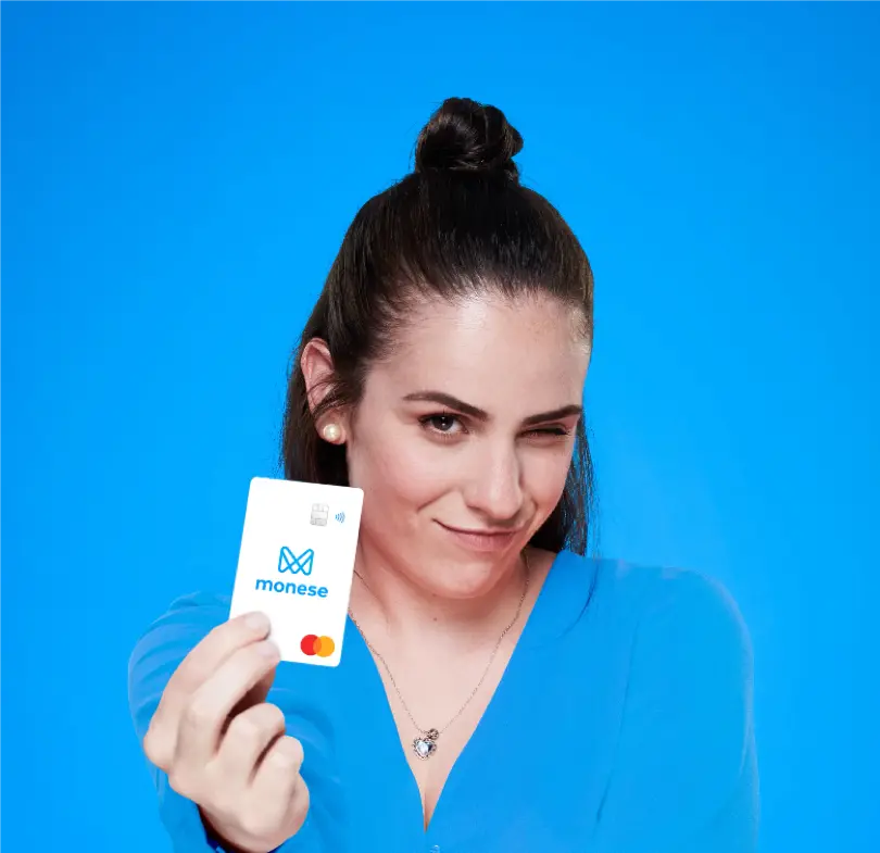 Monese customer holding a Monese card against a blue background